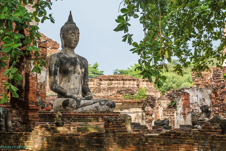 Buddha mezi zříceninou a stromy