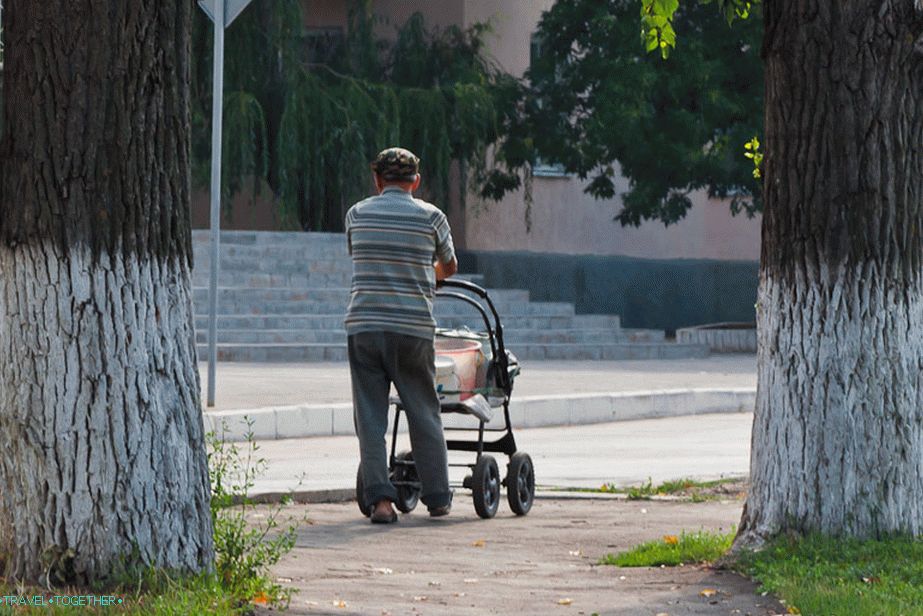 Muž nosí v kbelíku pro invalidní vozík