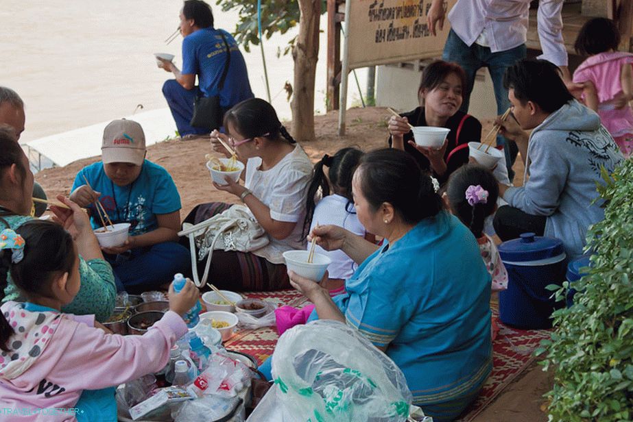 Celá rodina při obědě na břehu řeky Mekong