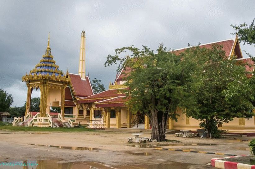 Velmi thajská fotka: krematorium, chrám, stůl pod stromem, kaluže a rána na zemi.